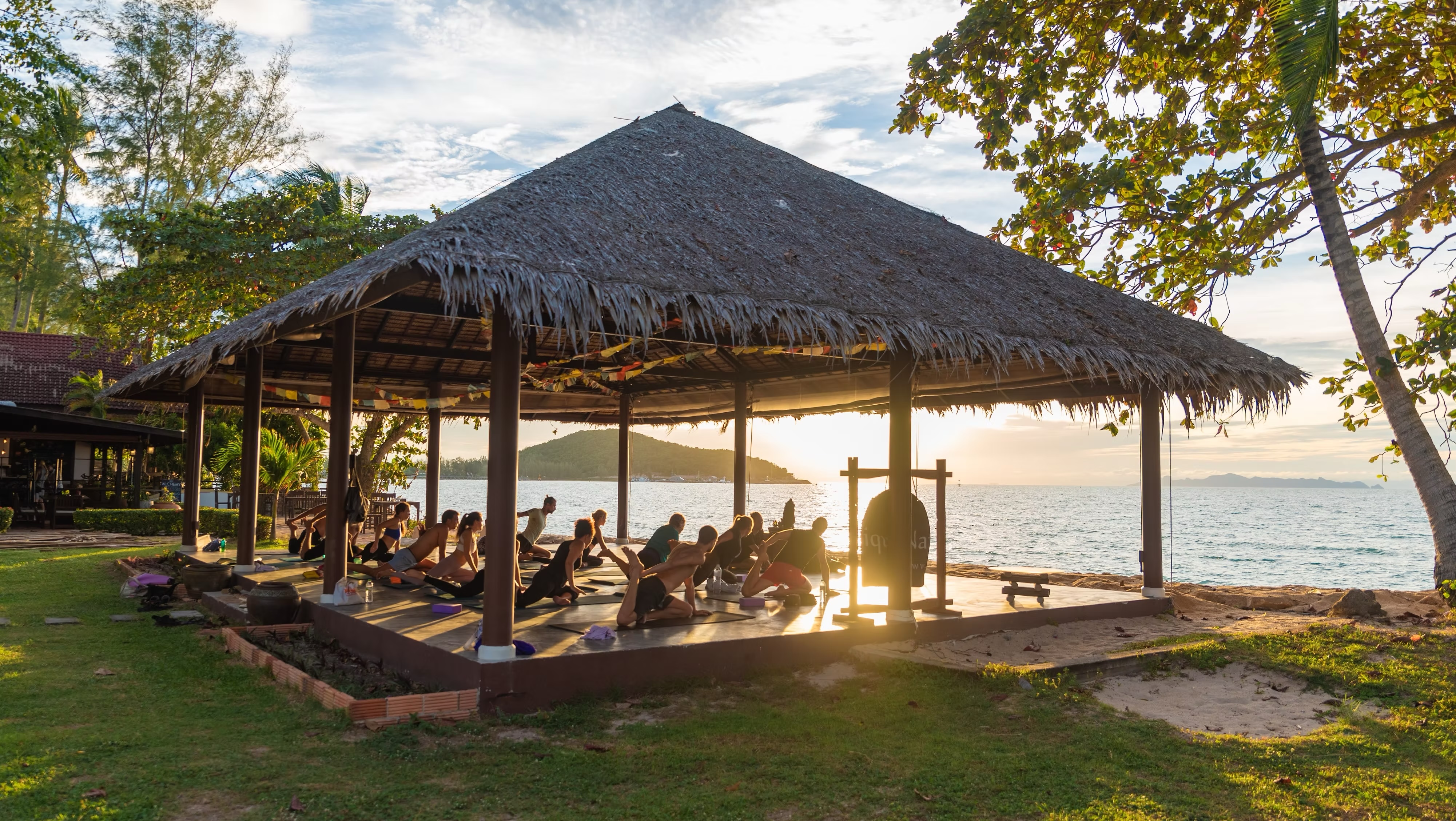 Person meditating on a beach at sunrise